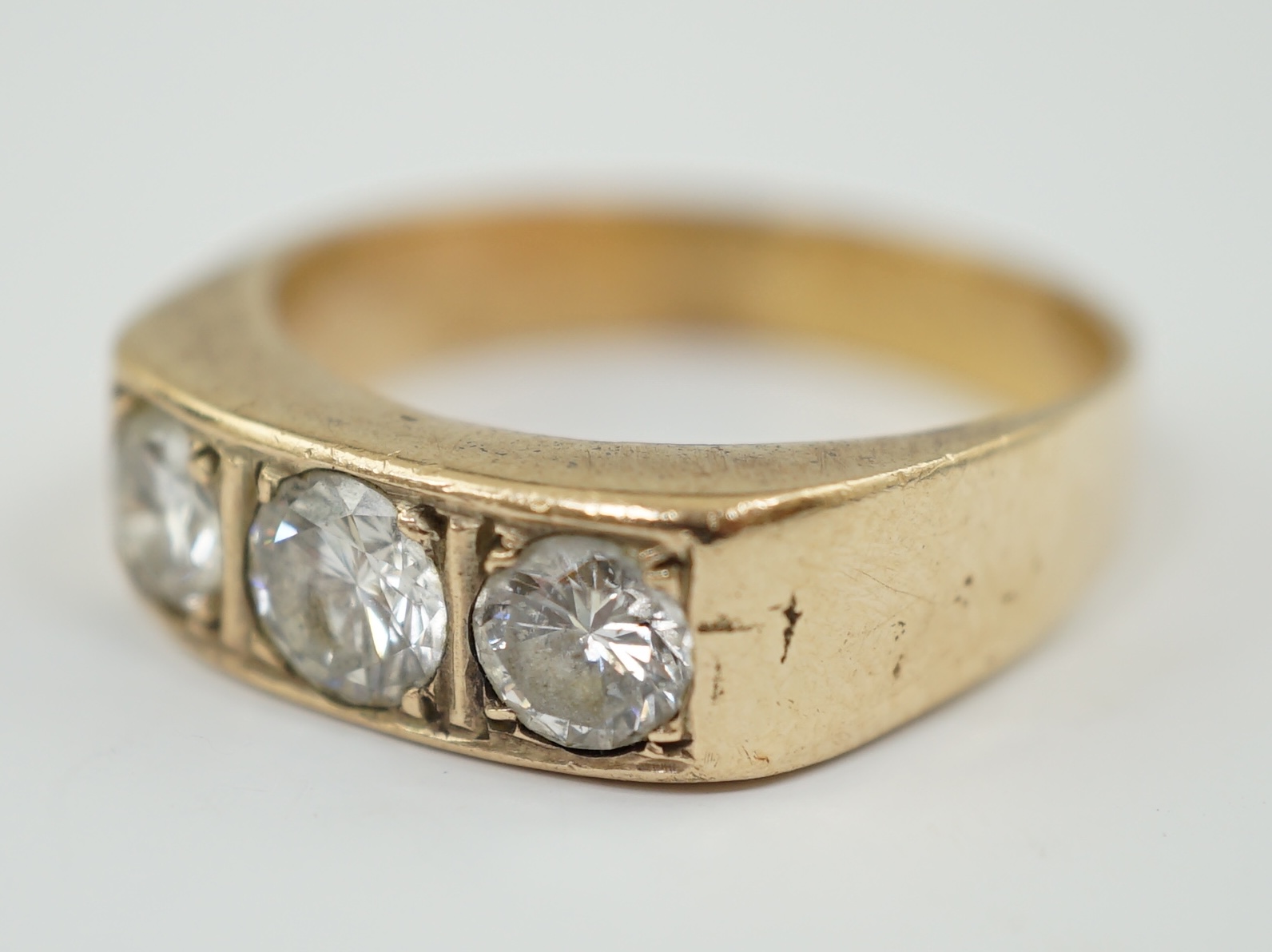 A gold and channel set three stone diamond ring